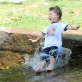 Joshua Allred, 3, slides and takes a spill on slippery rocks in a waterfall on Prairie Creek in Lake...