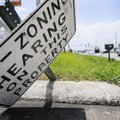 A sign notifying the public that the property owner requested the property be rezoned lies on its si...