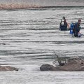 FILE — Search and rescue crews in dive gear search for victims near the Little Missouri River north ...