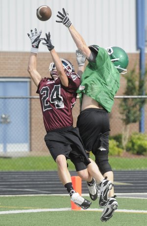 Gentry’s Dylan Ochs, left, reaches up for a pass as Van Buren’s Jimmy Barber defends during Monday’s session at the Rogers Heritage team camp in Rogers.