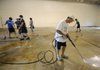 Steve Gordon, wrestling coach for Fayetteville High School, power washes the gym floor Tuesday at the former Jefferson Elementary School along with a few teammates and parents. The site will be the wrestling team’s new home until the new high school is built. Gordon hopes to start a summer conditioning program for wrestlers.