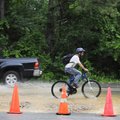Colby Thompson rides his bike home from work Wednesday through the flooded intersection of Old Wire ...