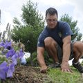 Brandon Deshane weeds the Butterfly Garden on Wednesday at First and Cherry streets in Rogers. Desha...