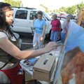 Rachel Allen of Fayetteville paints a portrait Friday during the 3rd Friday Twilight Walk in downtow...