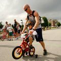 Noah Freisen, 3, crosses the three-mile finish line with a little help from his father, Shawn Friese...