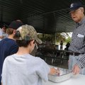  Jesse Coker, 89, with the Rogers Optimist Club serves hot dogs June 12 to children at the club’s fi...