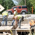 An Arkansas Highway and Transportation Department crew works Friday on a box culvert while traffic m...