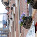 Steve Abb paints trim two stories above West Central Avenue on Tuesday in downtown Bentonville. The ...