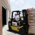 Quincey Barnard III moves pallets of rice and beans Wednesday into Randal Tyson Track Center in Faye...