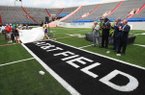 Cheerleaders from Mount St. Mary and Catholic High School uncover a logo Wednesday at War Memorial Stadium in Little Rock after an announcement naming the playing surface the AT&T Field. Announcing the sponsorship were (background left to right) Ed Drilling, AT&T Arkansas president; Terry Williams, Arkansas Veterans Commission chairman; Steve Gray, AT&T vice president and general manager; and Gary Smith, War Memorial Stadium Commission chairman.