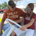 Sheriff’s Deputy Doug Gay gives Megan Glory, 12, of Bentonville a quick lesson Thursday on how to dr...