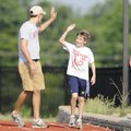 HELPING HIGH-FIVE - Jack Rossi, 10, middle, gives Travis Feltner, left, a high-five Thursday as Chas...