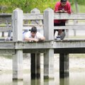 GONE FISHIN’ - Miguel Santillan, right, 13, fishes Thursday at Veterans Park in Rogers with cousin O...