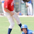 Rogers Merchants’ Zac Stewart is safe after a pickoff attempt during Friday’s game against the Roger...