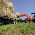 FIELD DAY - Keith Wright loads hay bales onto a trailer Friday in a field he leases near Greenland. ...