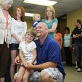Tate Courtney holds his daughter, Ally, as she is surprised Tuesday with a trip to Walt Disney World...