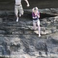 Jonathan Binam, left, and Eva Apple, both of Fayetteville, jump from a bluff Sunday at Riverside Par...