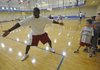 Former Fayetteville and University of Arkansas star Ronnie Brewer demonstrates a defensive drill Monday during his annual Brew Crew Basketball Camp at the Donald W. Reynolds Boys & Girls Club in Fayetteville.