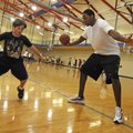 Former Arkansas Razorback Marcus Monk, right, works with children during Tuesday’s session of the Br...