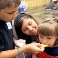 Josh Lopez, 7, and Anna Lopez, 12, give sister Abby Lopez a bite of cracker with butter Tuesday that...