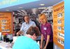 Howard Moore, left, Walmart Visitor Center on West Central coordinator, and manager Boo Randolph help Paula McCoy of Vinita, Okla., with her Tuesday purchase of T-shirts and postcards in Bentonville. The temporary center is at 110 W. Central Ave. and will be open until renovation to the original center on the Bentonville square is complete.