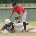 Springdale Tyson first baseman Chris Huebner, top, loses the ball as Springdale Kiwanis’ Blake Willi...