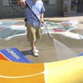 Joel Cervantes, custodian at Garfield Elementary School, washes carpets outside the school on Wednes...