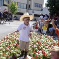 Jack Hamm, 4, left, and Ty Steele, 5, keep an eye out Wednesday for parade participants throwing can...