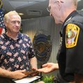 RESIDENT RECOGNITION - Rogers Police Chief Steve Hamilton, right, presents Dale Helgeson of Lowell w...