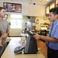 Steven Preaus, left, holds his daughter, Murphy, as he orders lunch from Omar Sandoval, swing manage...
