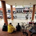  A group of motorcyclists wait out a light rain Saturday under the roof of the Walton Arts Center on...