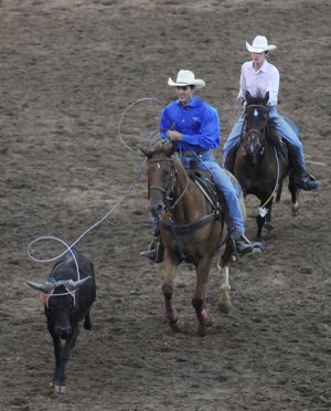 Tanner Shoop, front, and Trevor Shoop compete in the team roping competition Friday during the Rodeo of the Ozarks in Parsons Stadium in Springdale.
