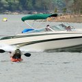  A kayaker and a speedboat occupy almost the same spot Sunday on Beaver Lake. Both vessels were crui...