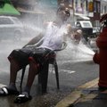 A person cools off in spraying water from a fire hydrant in the Kensington neighborhood of Philadelp...