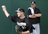 San Antonio pitching coach Glenn Abbott, right, watches as pitcher Corey Kluber works out before the start of Friday’s game against Northwest Arkansas in Arvest Ballpark in Springdale.