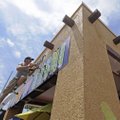 Dan Malloy of Fayetteville installs a neon sign Monday at a Dickson Street restaurant. The National ...