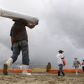 Workers assisting in cleanup of sand oiled by the Deepwater Horizon oil rig explosion and spill walk...