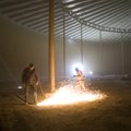 Leroy Gitchel, left, uses a torch to cut a section of steel flooring out of a 18 year old empty Spri...