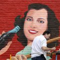 Chuck Bame of Rogers works on a vintage Coca-Cola mural Wednesday on the south side of the Davis bui...