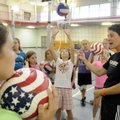 COACHING ASSIST - Volleyball coach Andrea Brinton reviews the previous lesson with children Thursday...