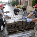 Abel Pera, left, and Manuel Cruz, both with J&L Concrete, stack bricks Thursday salvaged from a smal...