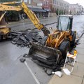 Rogers Street Department employees use construction equipment Thursday to remove the top layer of as...