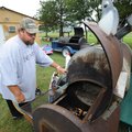 FOURTH ON THE RIVER - Henry Hickman, Elkins parks director, starts a fire in a smoker to allow it to...