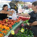 TOMATOES ARE TOPS - Xeng Lor, left, of Gentry sells a bag of tomatoes to Kay Owens of Rogers on Satu...