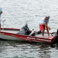 Cody Oxner, 14, pulls a bass into a boat by hand while fishing near the dam at Lake Windsor in Bella...
