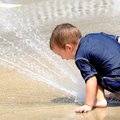 Reese Coleman, 3, plays in a jet of water at the Rogers Activity Center splash park on Sunday. He wa...
