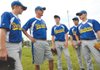 Kansas Shockers coach Tim Smith, second from left, huddles for a pregame meeting with his team Wednesday before their 14-and-under matchup against the Cardinal Baseball Club of Dallas at the USSSA World Series in Bentonville. The Shockers’ trip to the USSSA World Series was funded by donations from several businesses from their area in east central Kansas.