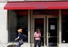 Customers and their dogs leave a Bank of America branch Thursday in New York.