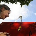 SUMMER SMILE - Emily Edwards, 9, of Rogers laughs after putting the finishing touches on her smiling...