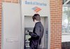 A man in Little Rock’s River Market District uses a Bank of America ATM on Friday.